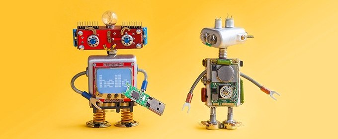 Two little robots stand next to each other.