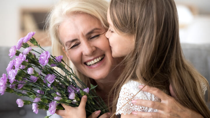 granddaughter kissing happy older grandma