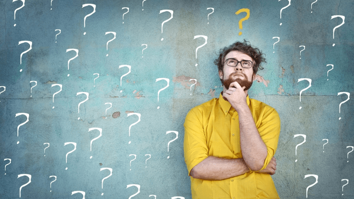 man thinking and leading on wall with question marks