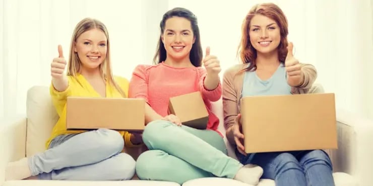 3 women happily holding open packages