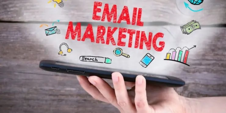 hand holding a tablet and the word email marketing is coming out of it
