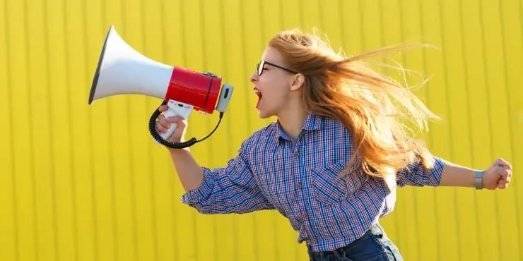 young woman yelling through megaphone