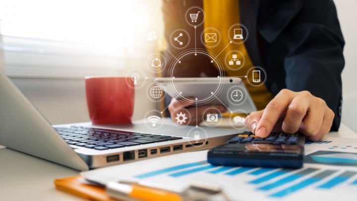 person working in the office with laptop calculator and tablet