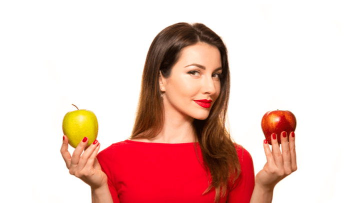 woman choosing between green and red apple