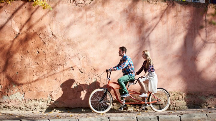 man and woman riding double bike