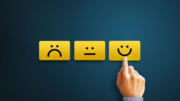 finger pushing a smiley face button