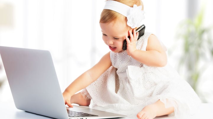 baby on laptop and telephone