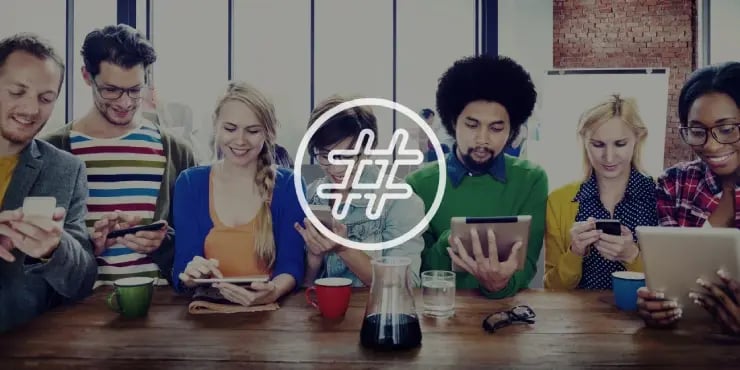 people in a meeting looking at their devices. A hashtag symbol sits in front of them.