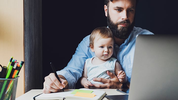 dad working on laptop with baby in his lap