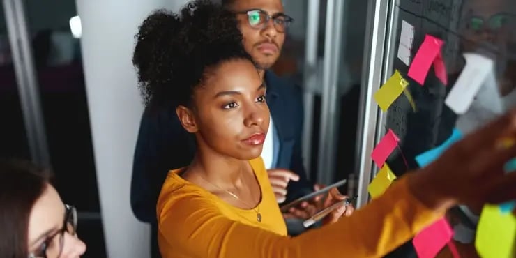 woman moving tickets on a physical board