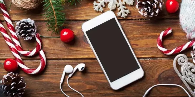 smartphone on a table with Christmas decorations around it