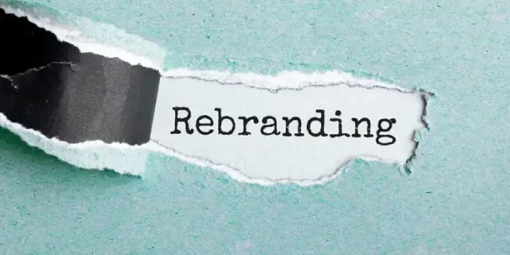 torn paper revealing the word rebranding