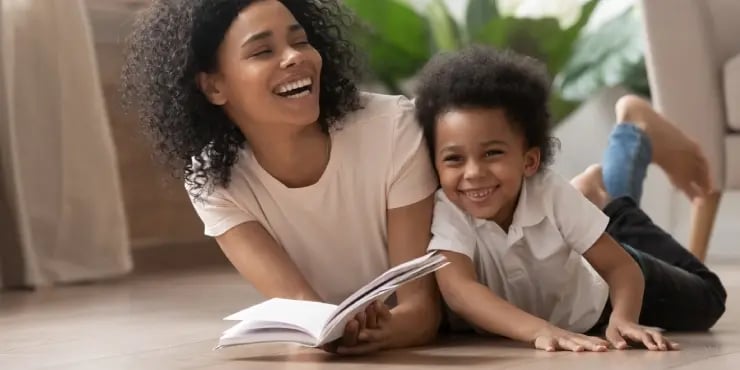 mother and son smiling and reading