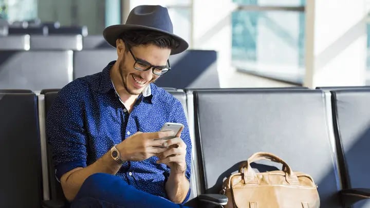man using smartphone in airport