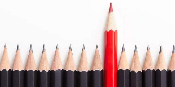 red pencil separating from a group of black pencils