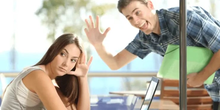woman ignoring overly eager man waving at her