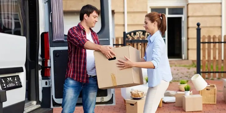 couple passing moving boxes