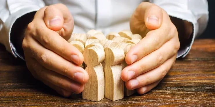 man holding wooden figurines