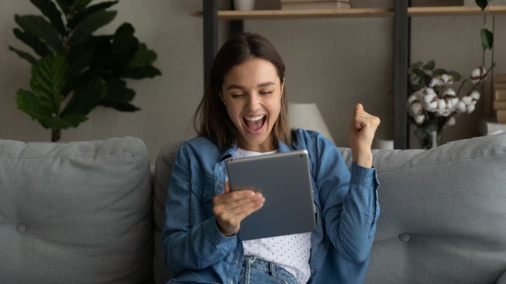 excited woman on tablet