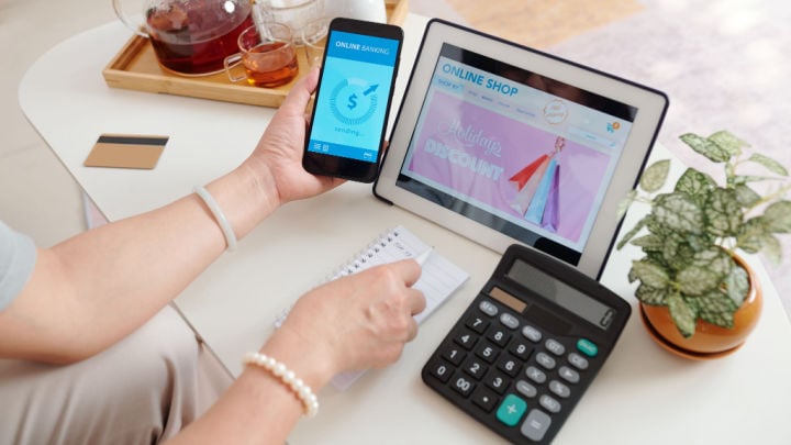 woman looking at bank balance, calculator, and online shop