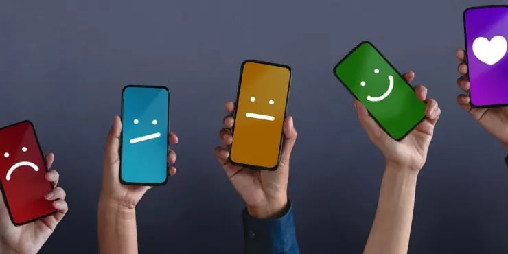 line of phones with faces ranging from frowning to smiling