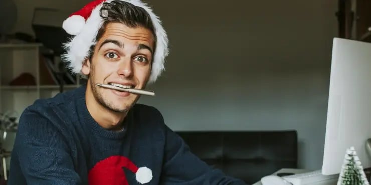 Young man with a christmas hat on working hard