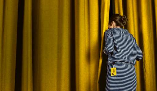 woman sneaking a peak through a theatre curtain