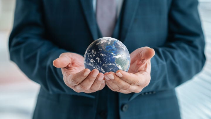 man in suit holding small globe
