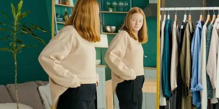 woman trying on new outfit at home