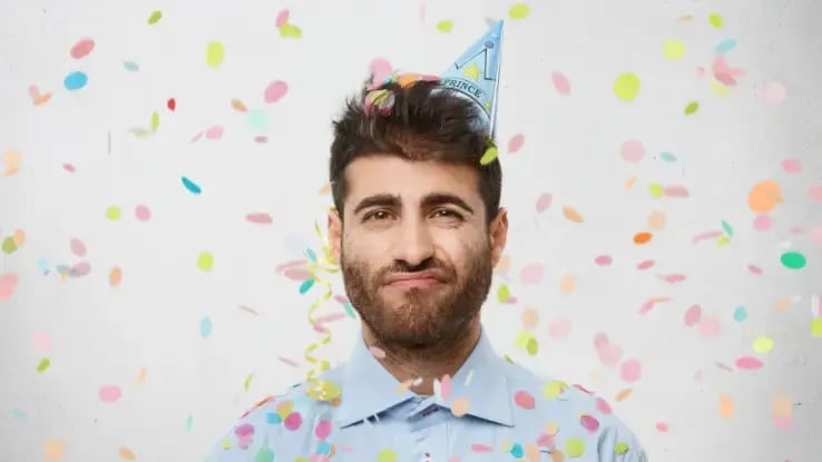 unhappy man wearing a birthday hat