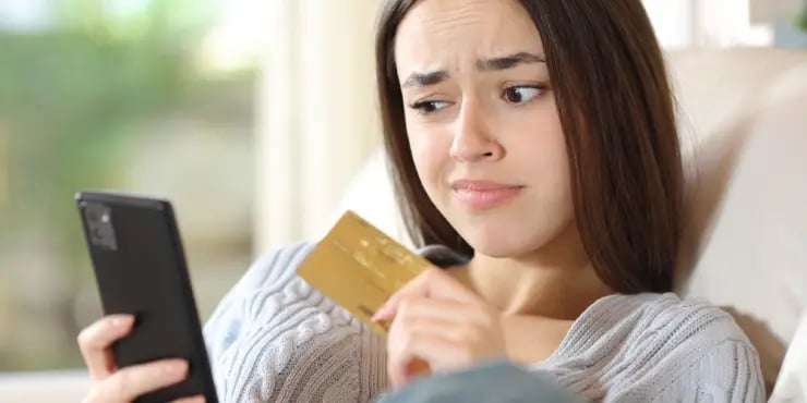 young woman looking at her phone suspiciously