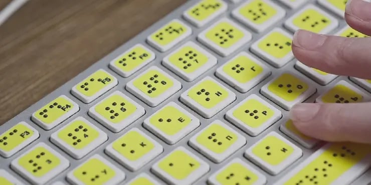 hand typing on keyboard with brail