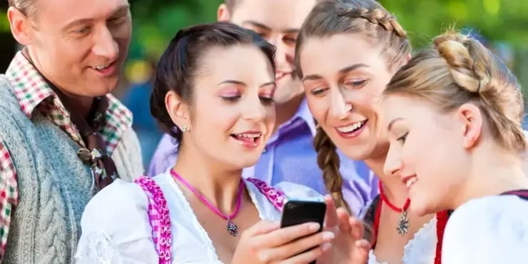 german friends gathered around smartphone