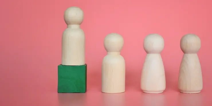 one wooden figurine standing above the others