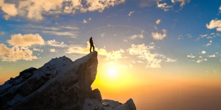A person standing on a mountain peak.
