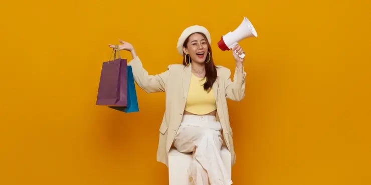 A happy shopper smiling and holding a megaphone.