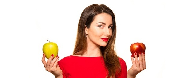 woman holding a yellow and a red apple